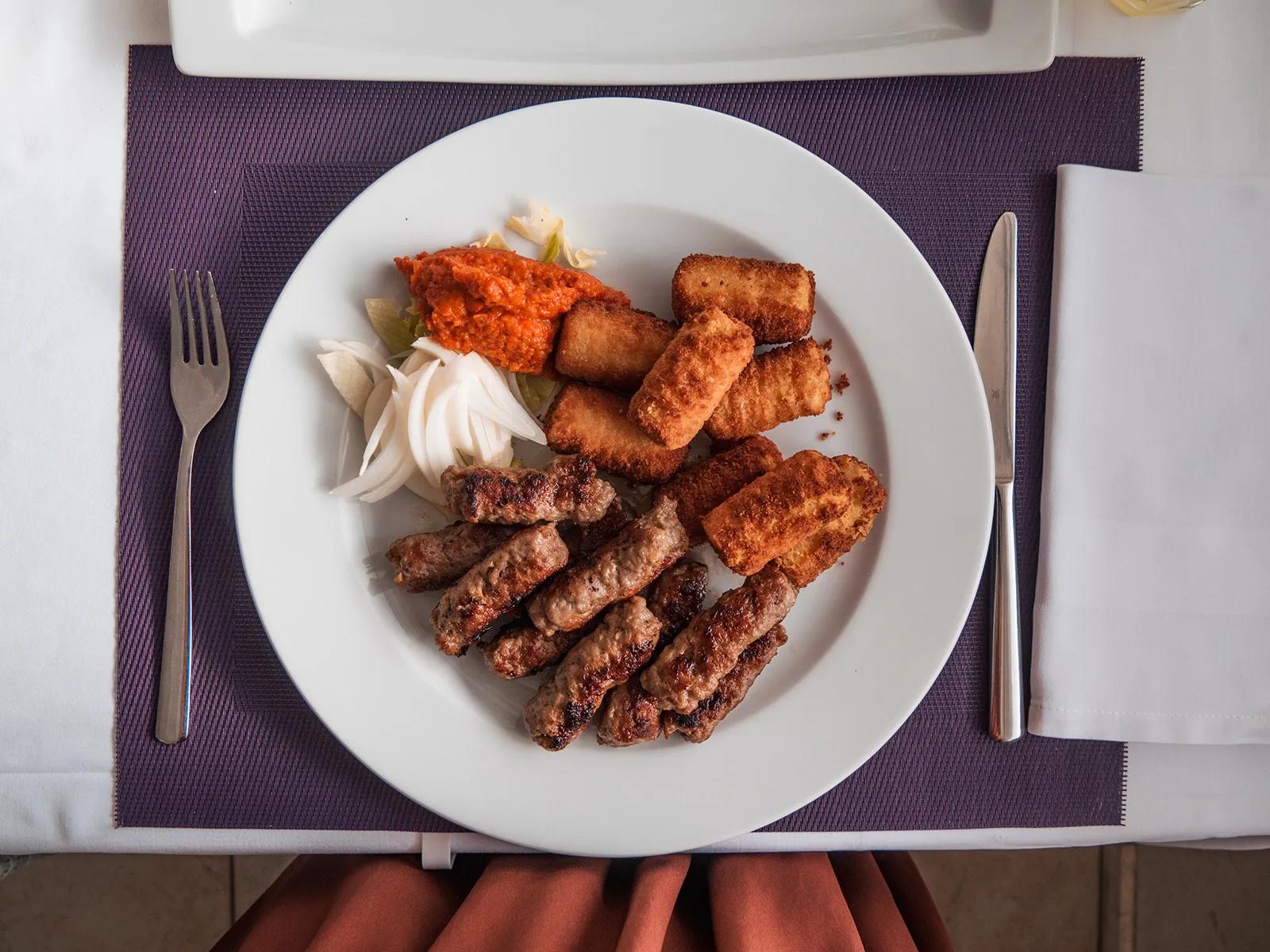 Cevapcici mit Kroketten, Ajvar und Zwiebeln